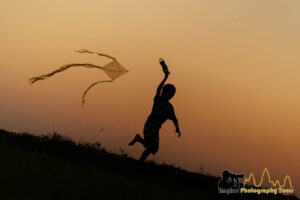 kid flying kite sunset cambodia