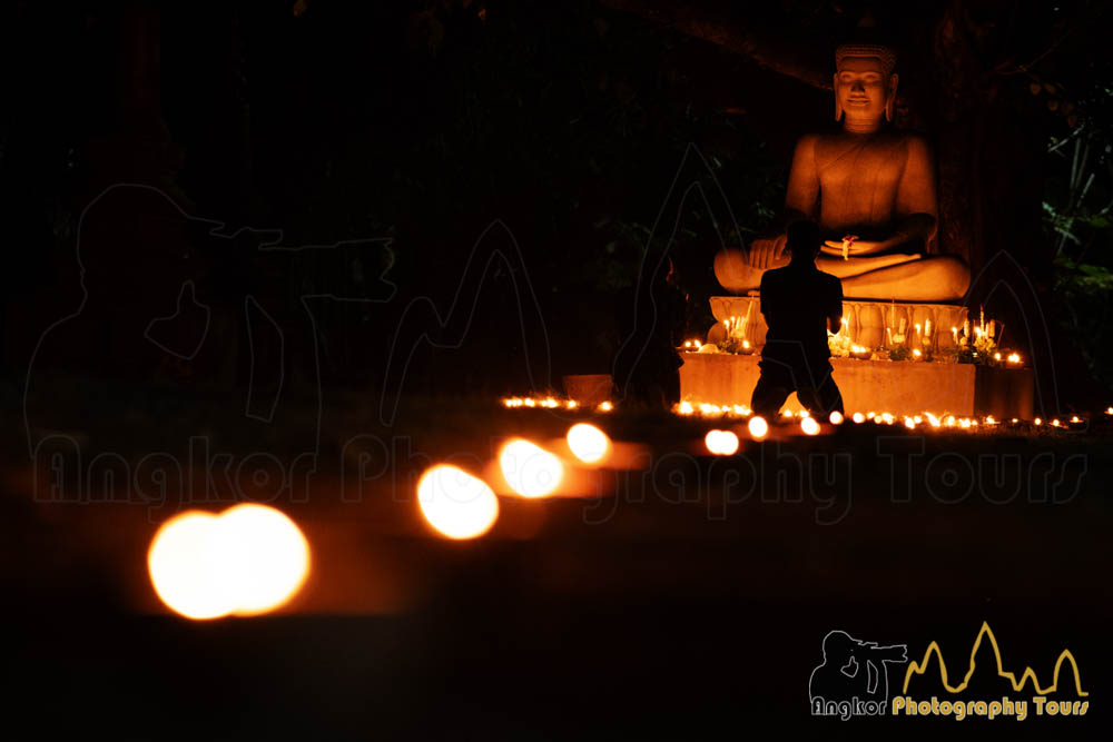 Cambodian praying in front of Buddha statue at Meak Bochea